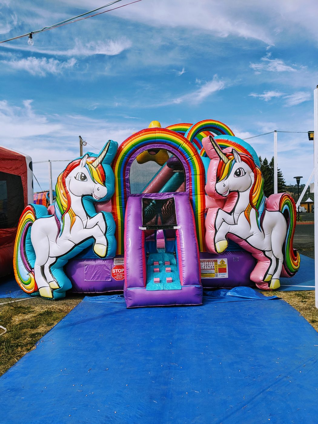 Unicorn-themed jump house with rainbow arch at Punky's